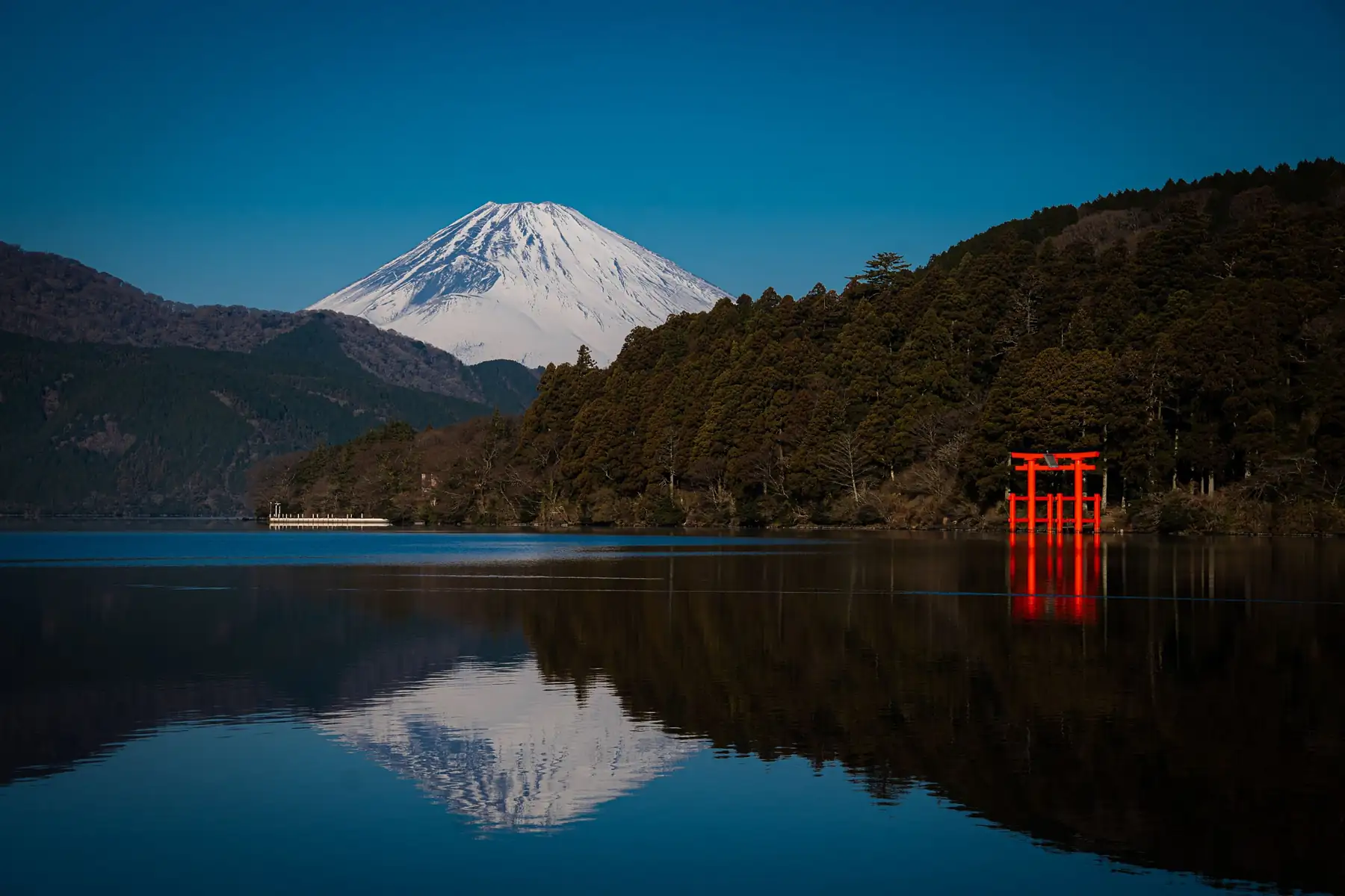 El monte Fuji y un torii rojo reflejados en el lago Ashi, en Hakone