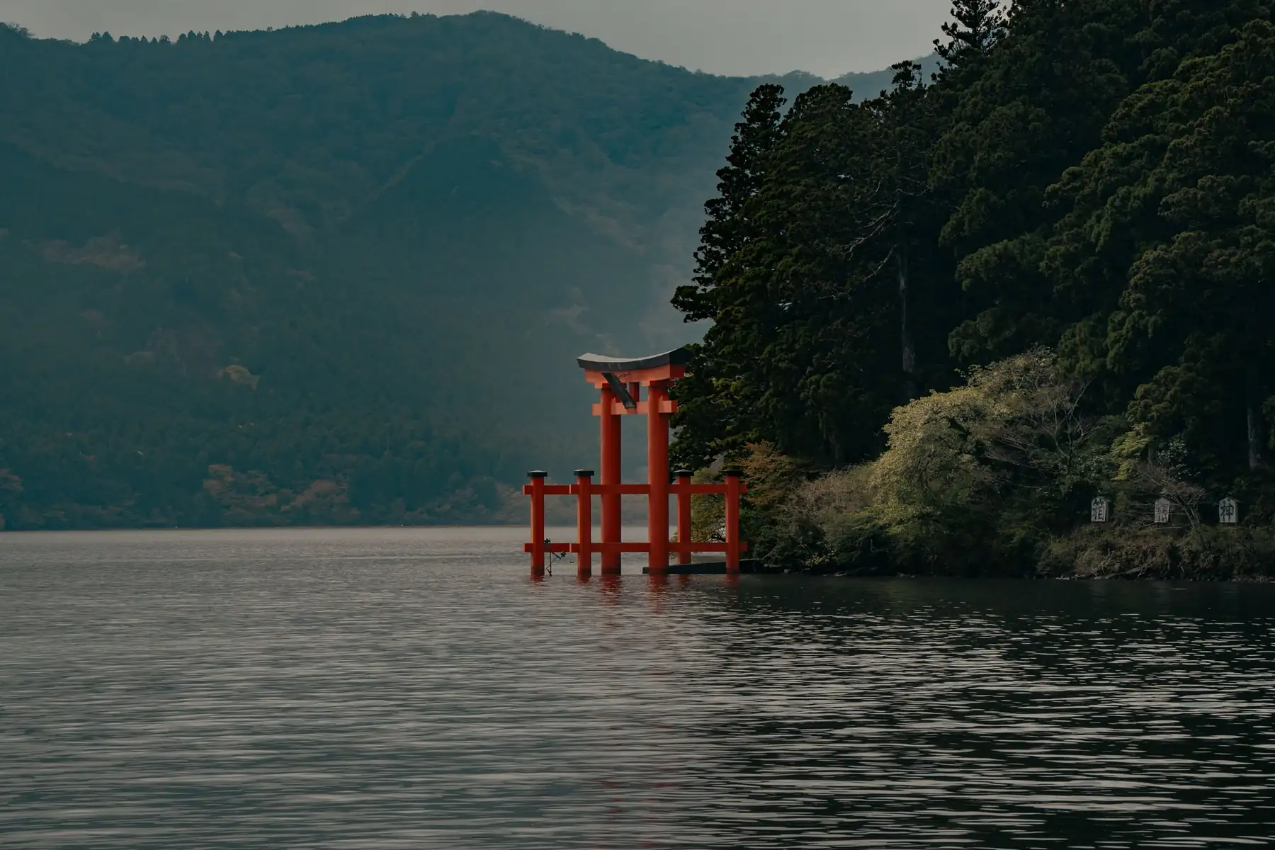Torii rojo sobre el agua del lago Ashi, en Hakone